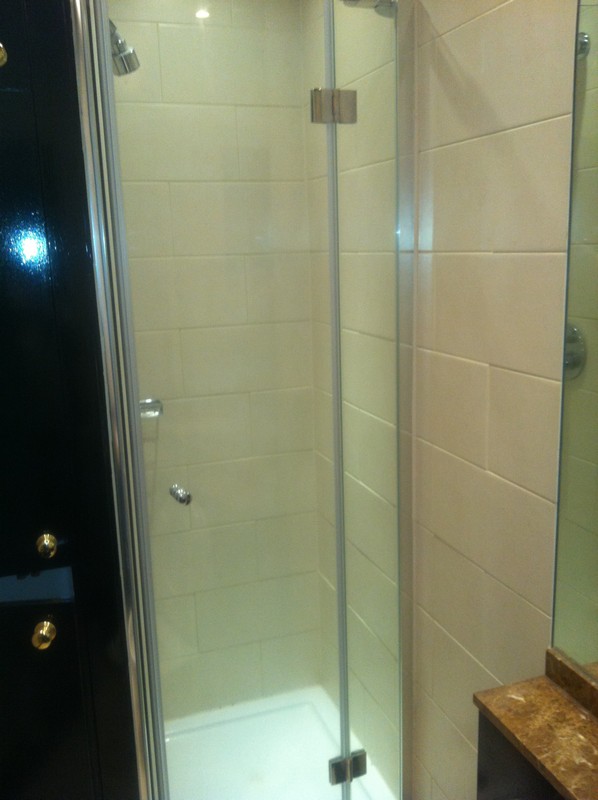 Frameless glass shower enclosure with chrome fittings in Thamesmead