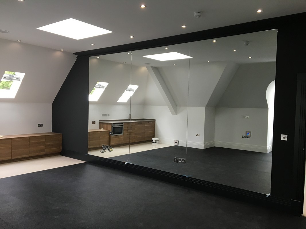 Frameless glass wall dividing loft conversion in Thamesmead