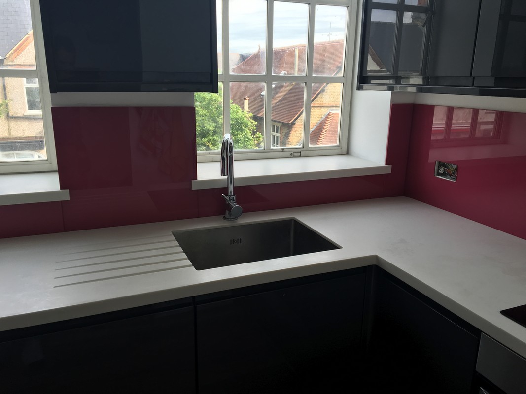Deep plum coloured glass splashback in modern Thamesmead kitchen